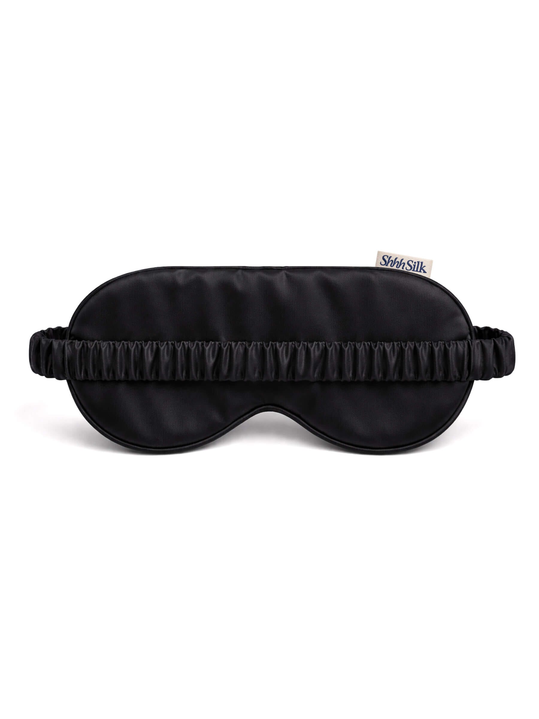 Black silk sleep mask with a brand label on a white background