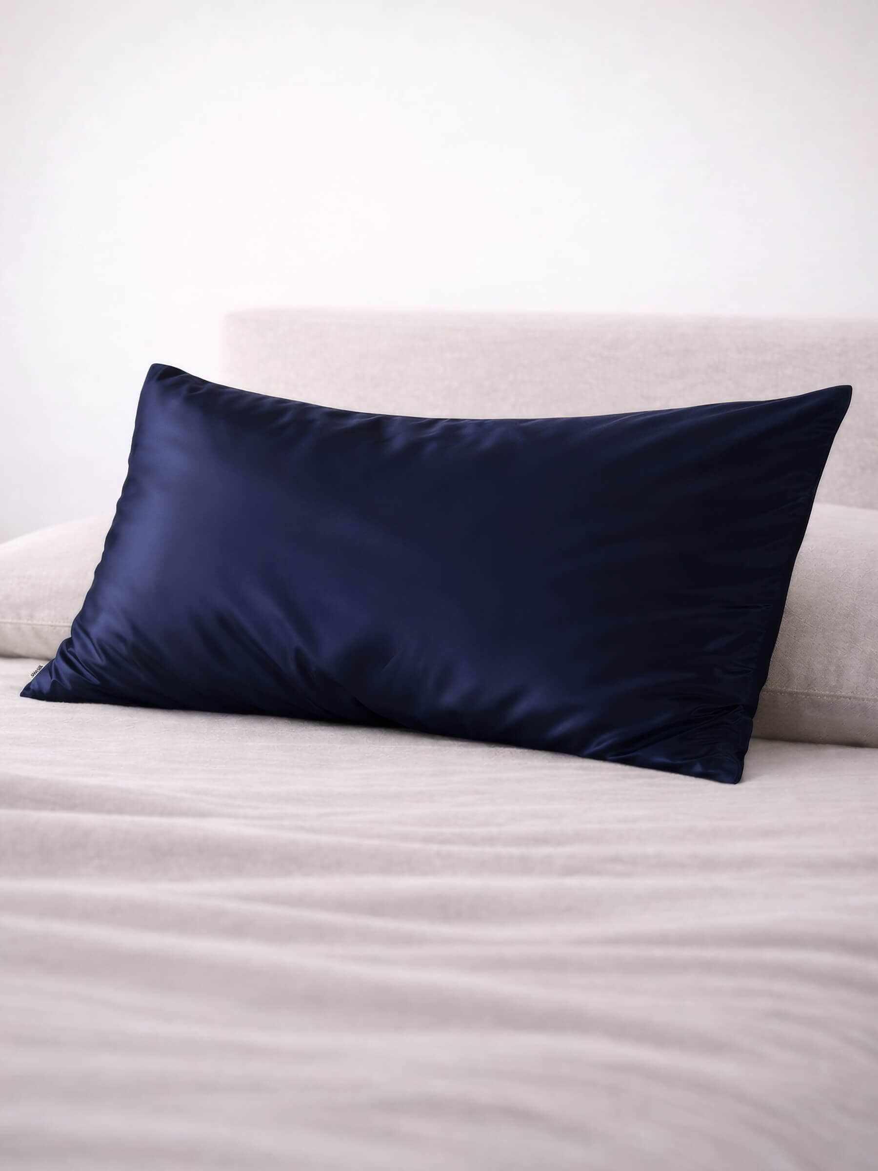 angled shot of a king size navy silk pillowcase on a bed