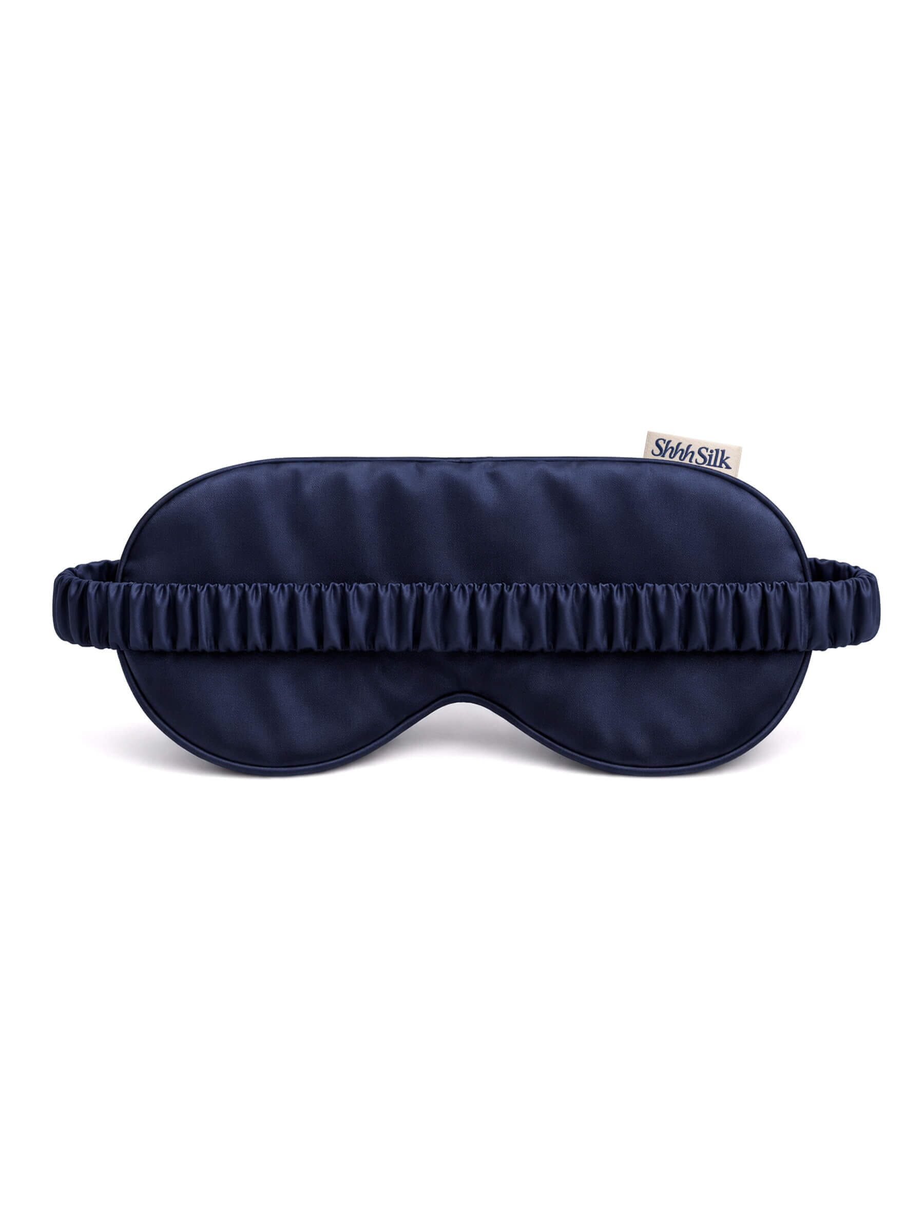 Navy silk sleep mask with a brand label on a white background