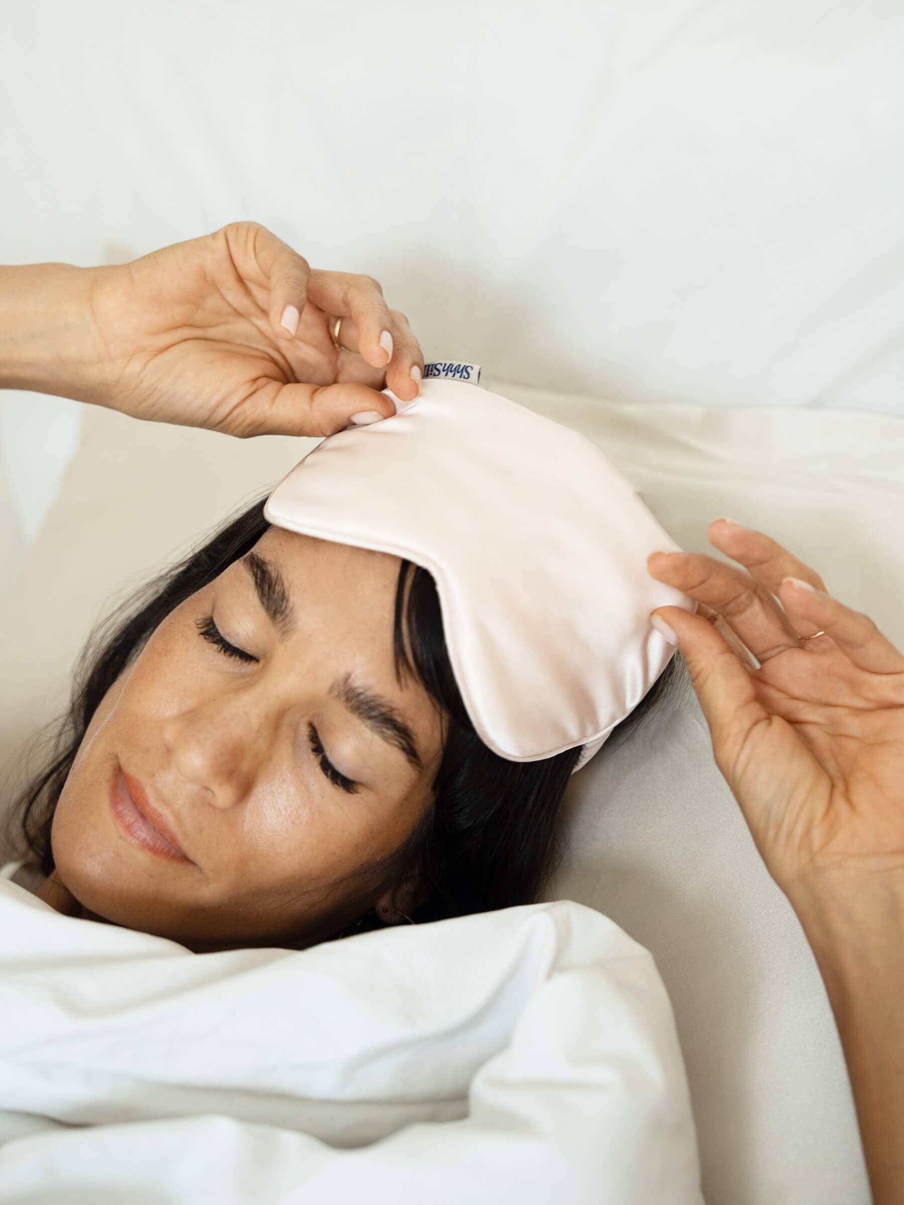 Woman wearing a white silk sleep mask
