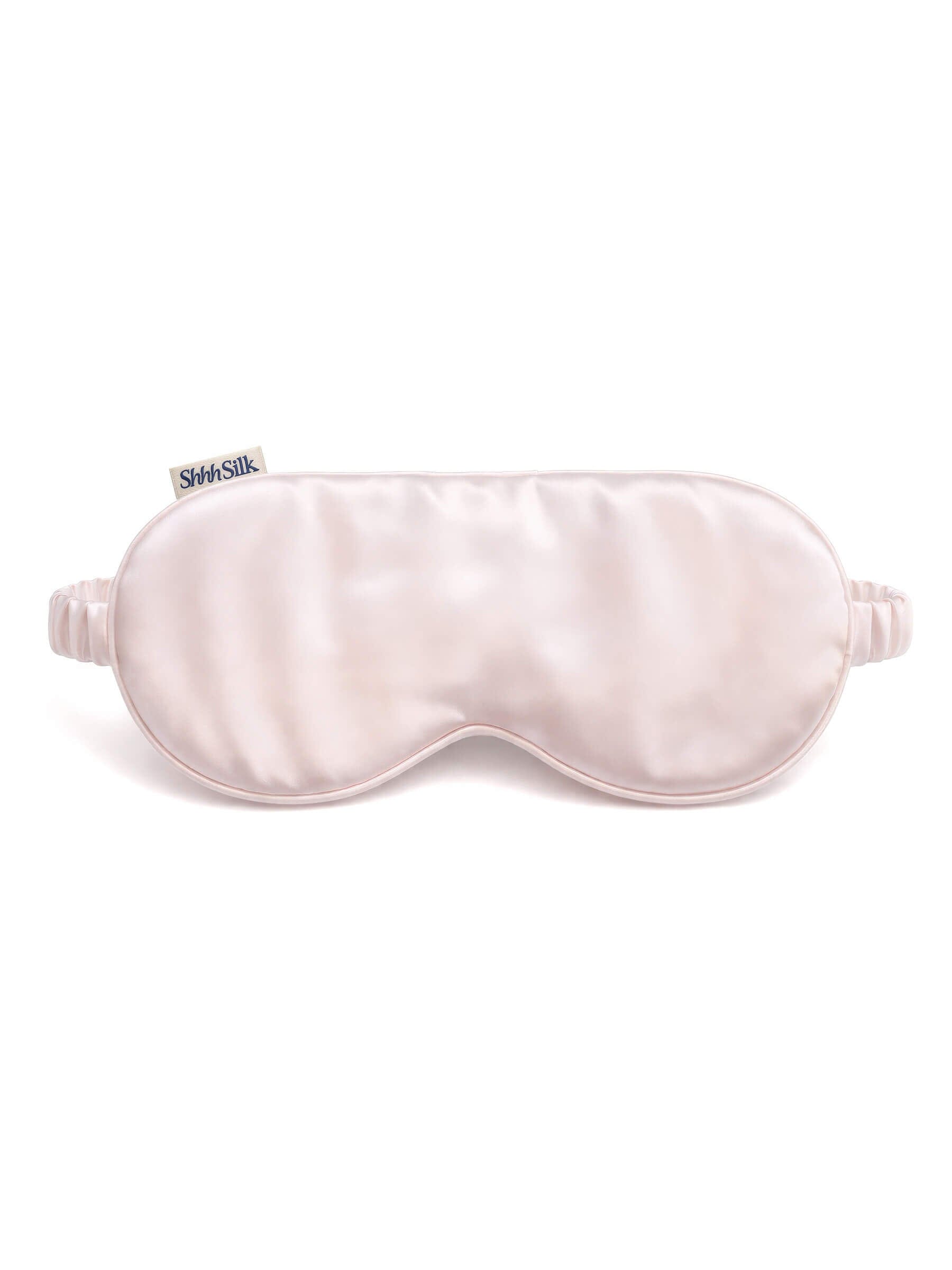Pink silk sleep mask on a white background