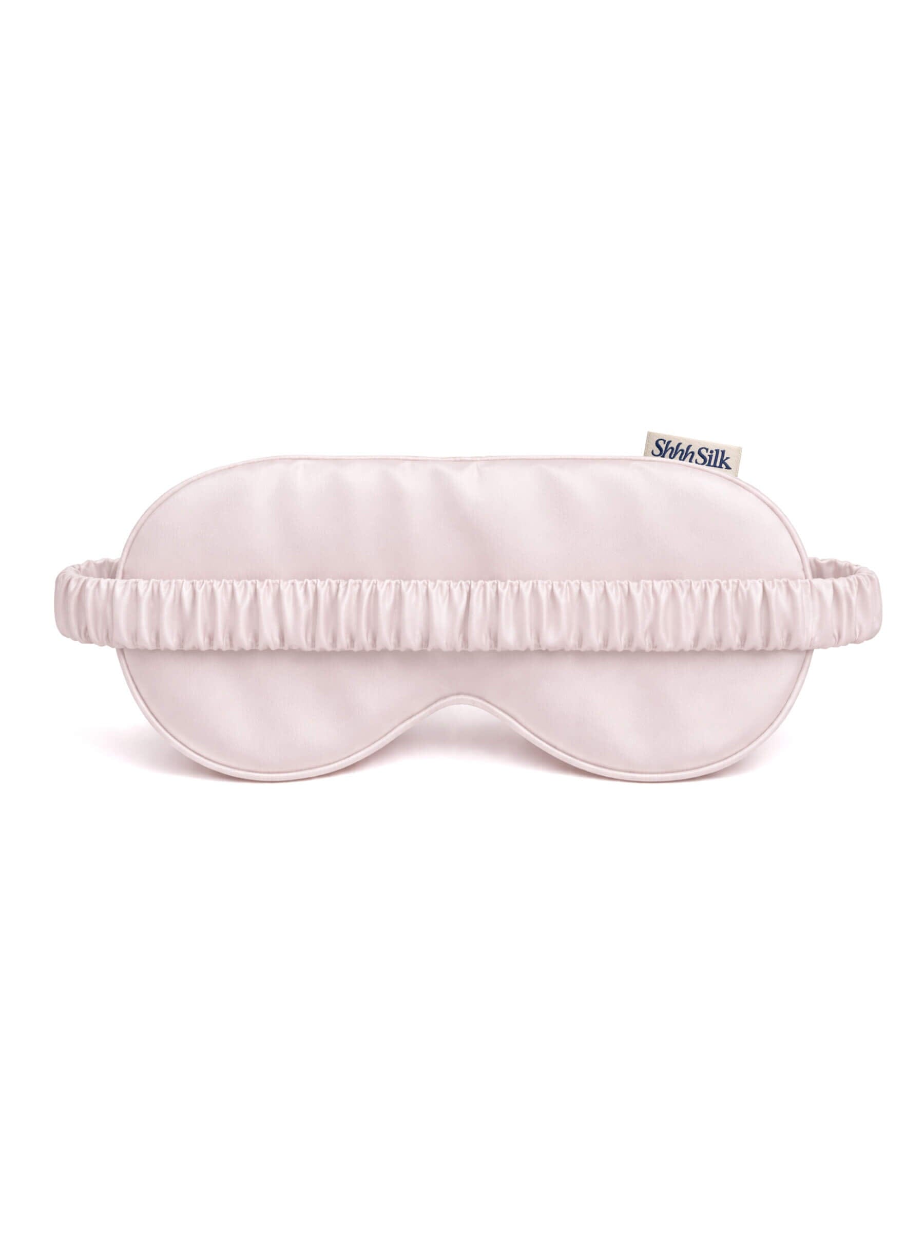 Pink silk sleep mask with brand logo on a white background
